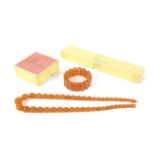 An opaque amber graduated oval bead necklace and a similar block bracelet.