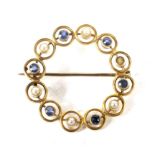 An early 20th century gold, sapphire and half-pearl open circlet brooch.