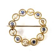 An early 20th century gold, sapphire and half-pearl open circlet brooch.
