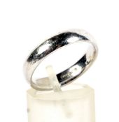 A modern 9ct white gold court-shaped wedding band.