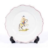 A Continental faience plate painted with an equestrian figure.