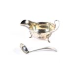 A silver sauce boat and a sauce ladle.