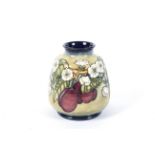 A Moorcroft vase with plums pattern.