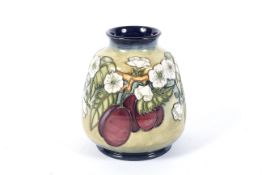 A Moorcroft vase with plums pattern.