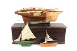A large vintage wooden pond yacht and two smaller examples, boxed.