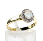A modern 18ct gold, opal and diamond oval cluster ring.