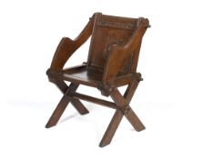 An early 20th century carved oak Glastonbury chair.