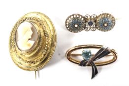 Three brooches. Comprising: a vintage bi-colour gold and pale blue zircon single stone oval brooch.
