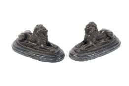 A pair of bronze models of lions on black marble bases after Barnie.