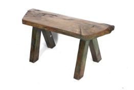 An elm pig bench of rustic shaped form with angular sides.
