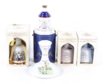 Four commemorative bottles of Bells scotch whisky and a Wade decanter.