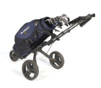 Range of golf clubs with bag and trolley.