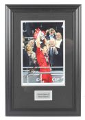 A signed photograph of Steven Gerrard lifting the Carling Cup.