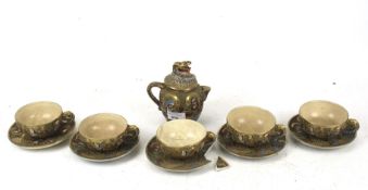 A 20th century Satsuma tea service. Including pot, five cups and four saucers. Max.