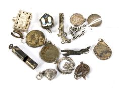 Fifteen Victorian and later silver and white metal charms. Including a bible, heart, whistle, etc.