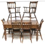 A rectangular stained pine kitchen dining table and six chairs.