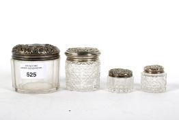 Four silver topped glass jars.