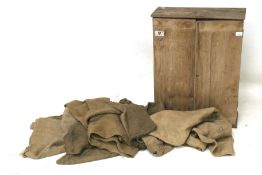 A rustic pine carpenter's cabinet and a selection of vintage burlap sacks.