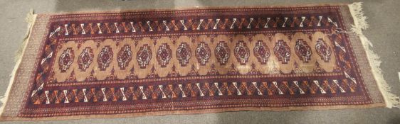 A Persian style carpet runner. On a red ground.
