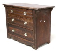 A stained pine chest of three drawers. With replacement handles.