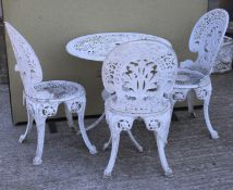 A circular white painted metal garden table and three chairs.