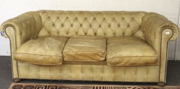 A contemporary three seater tan Chesterfield sofa.