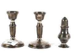 A pair of 20th century silver candlesticks and silver shaker.