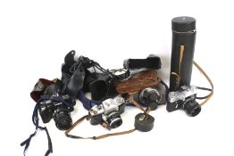 A collection of assorted vintage film cameras and lenses.
