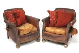 A pair of vintage brown leather armchairs.