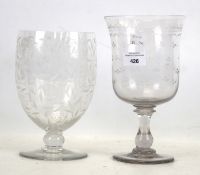 A 19th century glass vase and one other. Both with engraved details and circular bases, Max.