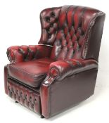 A 20th century burgundy leather Chesterfield wingback armchair.