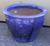 A large blue glazed ceramic garden plant pot.