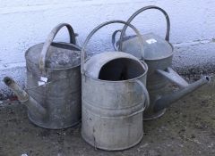 Three galvanised watering cans.