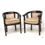 A pair of tub style mahogany framed open armchairs. With cane seats and backs.