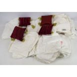 A box of table linen and textiles. Including tablecloths, place mats, miniature cushions, etc.