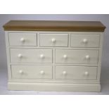A modern white painted softwood oak top chest of seven drawers.