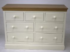 A modern white painted softwood oak top chest of seven drawers.