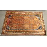 A Persian style rug. Of rectangular form with floral details on a red and orange ground.