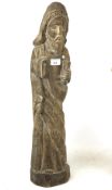 A naive carved pine figure of Christ carrying a book.