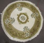 A circular Chinese style rug. The decoration on a cream and green ground.