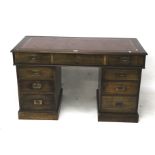 An early 20th century stained beech twin pedestal campaign style desk.