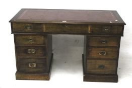 An early 20th century stained beech twin pedestal campaign style desk.