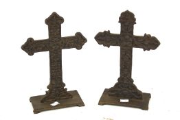 A pair of cast metal door stops modelled as crosses.