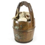 A Chinese wooded well bucket containing a large quantity of seashells.