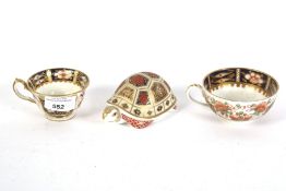 A Royal Crown Derby tortoise and two cups.