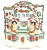 A 19th century Staffordshire ceramic watch stand. In the form of a castle with two cherubs.