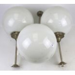 Three contemporary white glass globe ceiling lights.