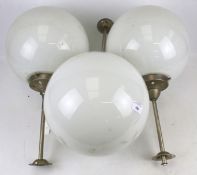 Three contemporary white glass globe ceiling lights.
