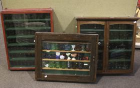 A collection of circa 212 glass eye baths in three display cabinets.