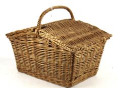 A wicker picnic basket with contents.